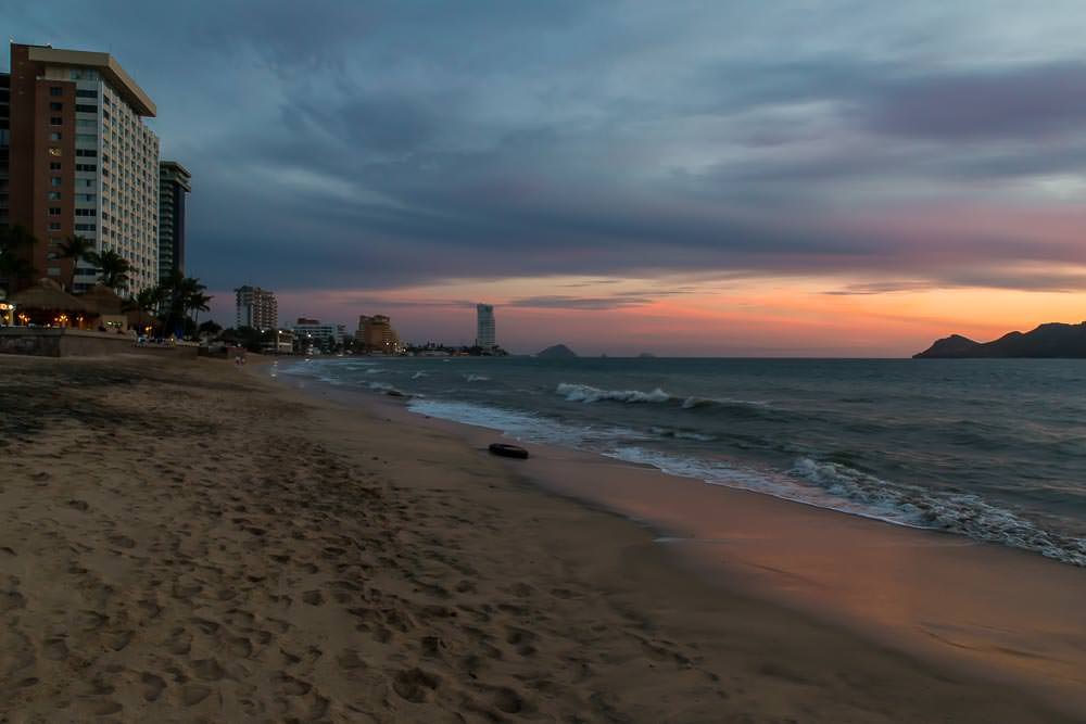 Still a nice sunset, but it loses some of the magic between the high-rise buildings and the abandoned tyre washed up on shore.